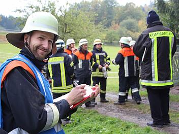 Gruppenführer Florian Güßbacher (links) stellt seine Löschtruppe vor. Sie ist zur Prüfung angetreten.