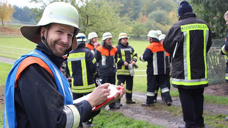 Gruppenführer Florian Güßbacher (links) stellt seine Löschtruppe vor. Sie ist zur Prüfung angetreten.