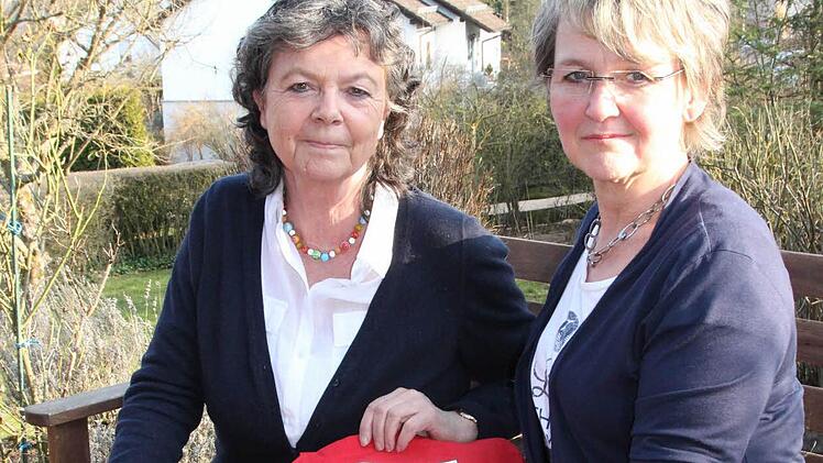 Die roten Taschen stehen sinnbildlich für die roten Zahlen in den Geldbörsen der Frauen. Karin Reinshagen und Birgit Fischer vom Bad Kissinger Frauenbund wollen heute in der Innenstadt aufklären.  Foto: C. Schmitt