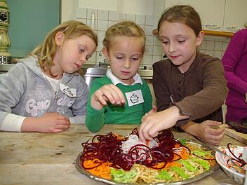Alina, Sophia und Angelina (von links) bereiten eine bunte Gemüseplatte zu.  Foto: Heike Schülein