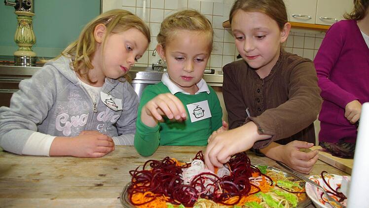 Alina, Sophia und Angelina (von links) bereiten eine bunte Gemüseplatte zu.  Foto: Heike Schülein