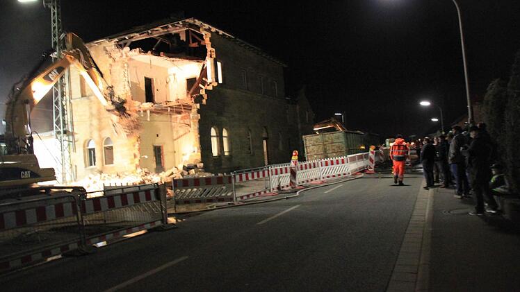 Etliche Ebensfelder verfolgen aus sicherer Distanz den Abbruch des Bahnhofs bis spät in die Nacht hinein; einige scherzen angesichts der fallenden Steine, andere bedauern den Abriss des historischen Baus.
