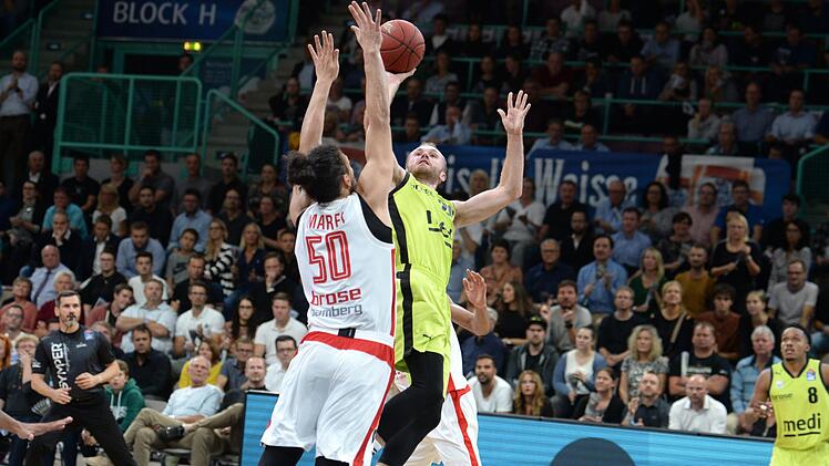 Der ehemalige Bayreuther Assem Marei (links) gewann bei seinem Punktspieldebüt für Brose Bamberg gleich an alter Wirkungsstätte. Hier blockt er den Wurfversuch von Bryce Alford . Foto: Peter Mularczyk