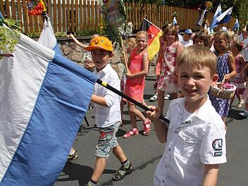 Die Fahnen wurden beim Festzug des Ziegelhüttener Wiesenfests vom Terrassenhaus bis zur Schule immer schwerer, aber die Jungs hielten tapfer durch. Foto: Sonja Adam