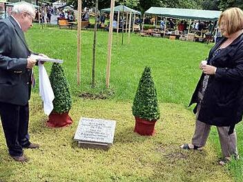 Der Vorsitzende des Vereins der Freunde und Förderer der Himmelkroner Heime, Erich Popp, und Alexandra Schuberth (Offene Hilfen) enthüllten den Gedenkstein im Schlosspark. Foto: Sebastian Müller