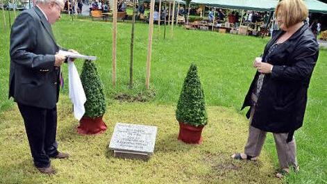 Der Vorsitzende des Vereins der Freunde und Förderer der Himmelkroner Heime, Erich Popp, und Alexandra Schuberth (Offene Hilfen) enthüllten den Gedenkstein im Schlosspark. Foto: Sebastian Müller