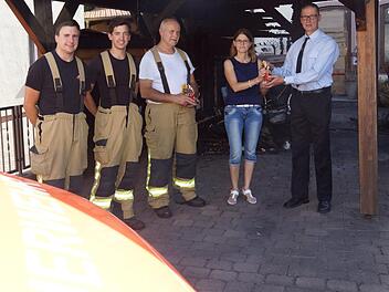 Manuel Wurst, Julian Leurer und Walter Emmert von der Hammelburger Feuerwehr sowie Ivo Straube von der Feuerwehr Untereschenbach nehmen von Ulrike Zehner eine Aufmerksamkeit entgegen. Arkadius Guzy