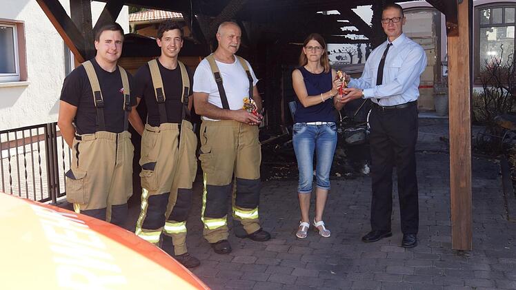 Manuel Wurst, Julian Leurer und Walter Emmert von der Hammelburger Feuerwehr sowie Ivo Straube von der Feuerwehr Untereschenbach nehmen von Ulrike Zehner eine Aufmerksamkeit entgegen. Arkadius Guzy