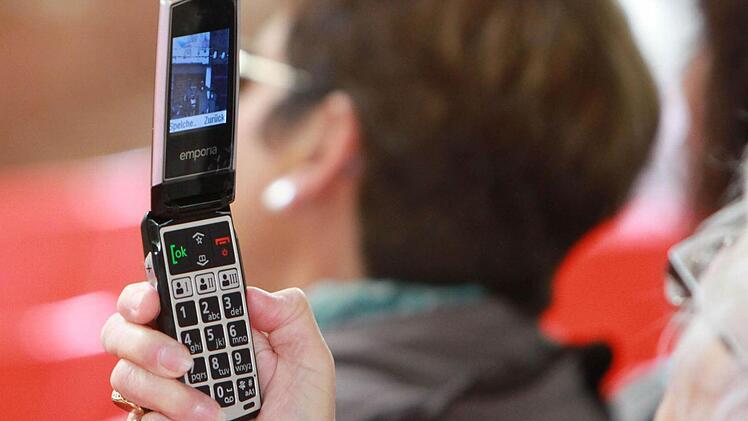 Eine ältere Dame im Publikum "schießt" ein Erinnerungsfoto mit ihrem Handy.