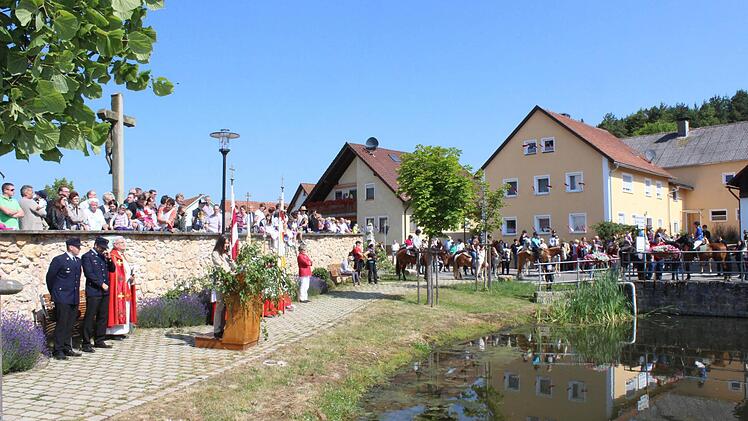 Die Reiterschar hat sich rund um den Dorfweiher formiert.
