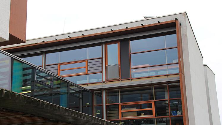 Dort, wo an der Fassade der Höchstadter Realschule heute Latten und eine Plane angebracht sind (linkes Bild), riss 2013 ein Sturm mehrere Bleche ab. Diese sollen eigentlich die Holzkonstruktion  der Regalfassade vor Regen schützen (rechts oben). Allerdings stellte man fest, dass die Schraubenlöcher offen gelegen waren, Wasser eingedrungen war und das Holz zu modern begonnen hatte.Christian Bauriedel