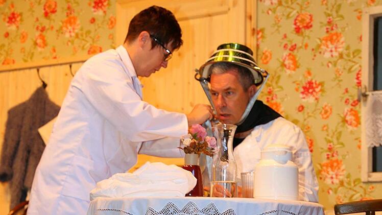 Dr. C&auml;cilia Obertal (Sabine G&ouml;bel) bringt  bei Paul (Edmund Welsch) den L&uuml;gendetektor  an. Foto: Gerd Klemenz