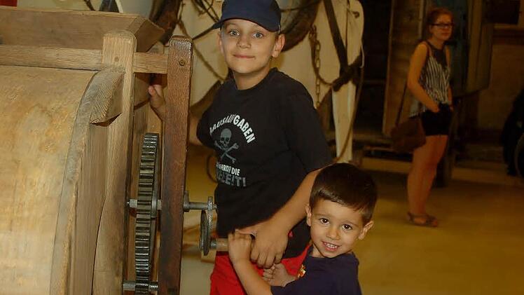 Tarek Langguth (stehend) und Max Krempel an einer alten Dreschmaschine