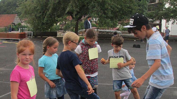 An den Spiel- und Spaßstationen "Schullandheim-Revival" tragen die Kinder ihre Ergebnisse in die Laufzettel ein. Foto: Laura Mühlrath