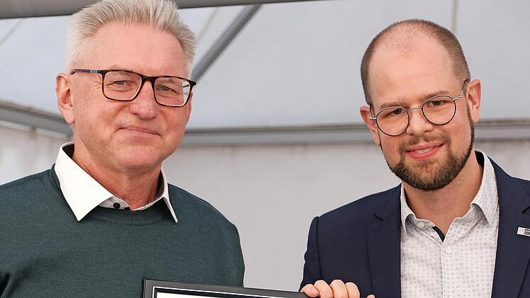 Justiziar Jan-Markus Momberg (rechts) von der IHK Würzburg überreicht die Ehrenurkunde an Geschäftsführer August Schneider.