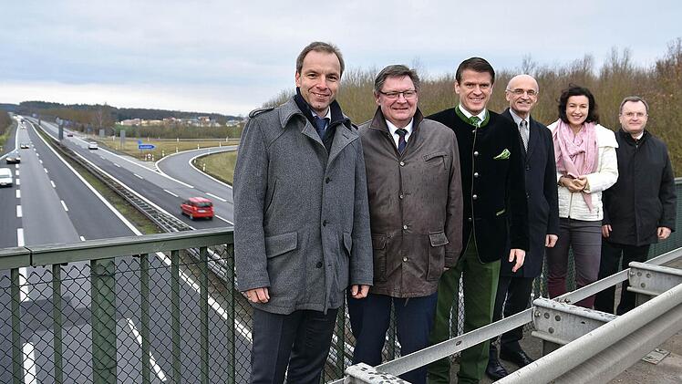 Gute Nachrichten für Horhausen (im Hintergrund) haben der bayerische Innen- und Verkehrsstaatssekretär Gerhard Eck (Zweiter von links), die Parlamentarische Staatssekretärin im Bundesverkehrsministerium, Dorothee Bär, und der Präsident der Autobahndirektion Nordbayern, Reinhard Pirner (rechts), zu Weihnachten mitgebracht. Denn die Fahrbahn der A70 (im Bild) wird erneuert und verspricht eine deutliche Lärmreduzierung. Mit im Bild Landrat Wilhelm Schneider (Dritter von rechts), MdL Steffen Voge...