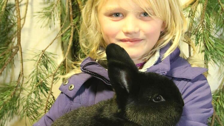 Angeline hält eins ihrer Kaninchen.  Foto: Michael Stelzner