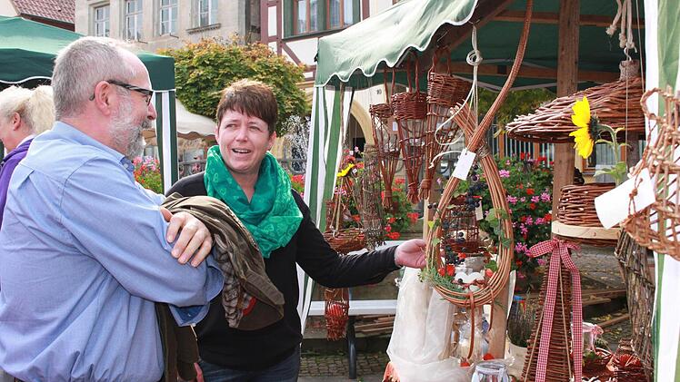 Irene Mock aus Jesserndorf zeigt einem Kunden ihre selbst gefertigten Weiden-Kunstwerke. Und, auch ein Vorteil bei einem solch kleinen Markt, sie kann mit manchem Besucher fachsimpeln. Foto: Katharina Becht
