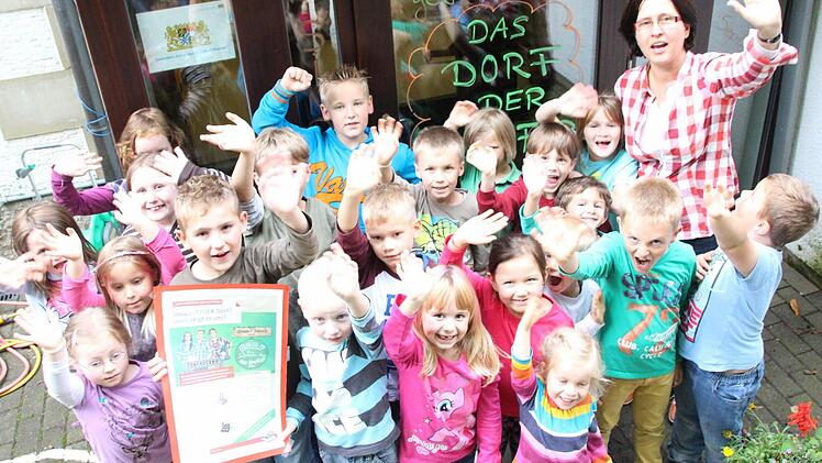 Die Kinder des Nüdlinger Kindergartens mit Leiterin Anette Postolov bejubeln den Sieg beim "Dorf der Dörfer"-Wettbewerb.  Fotos: Benedikt Borst