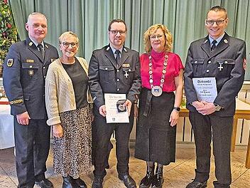 Die Geehrten Sebastian M&uuml;ller (Mitte) und Rolf Bergmann (rechts) mit B&uuml;rgermeisterin Anja Gebhardt (2.v.r.), stellvertretender Landr&auml;tin Rosi Kraus (2.v.l.) und Kreisbrandrat Oliver Flake.