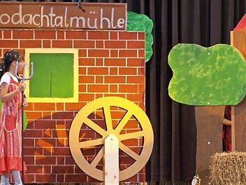Der Hahn (Leon Schmidt) stärkt sich, bevor er vor der Bäuerin (Emma Wich-Heiter) Reißaus nimmt. Foto: Susanne Deuerling