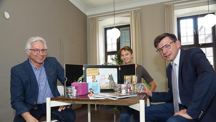 Joachim Hockgeiger vom Freundeskreis Lesezeichen, Bibliotheksleiterin Karin Wengerter und Bürgermeister Armin Warmuth präsentieren die neuen Ausleihmedien.Foto: Arkadius Guzy