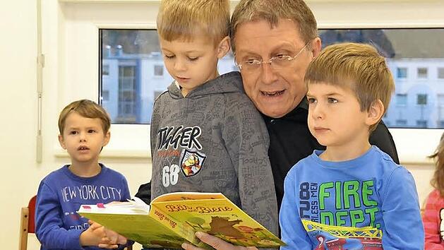 Der fünfjährige Jonas (vorne links) und der vierjährige Jakob (rechts) genießen den Sonderplatz bei der Vorleserunde auf dem Schoß von Oberbürgermeister Henry Schramm. Foto: Uschi Prawitz
