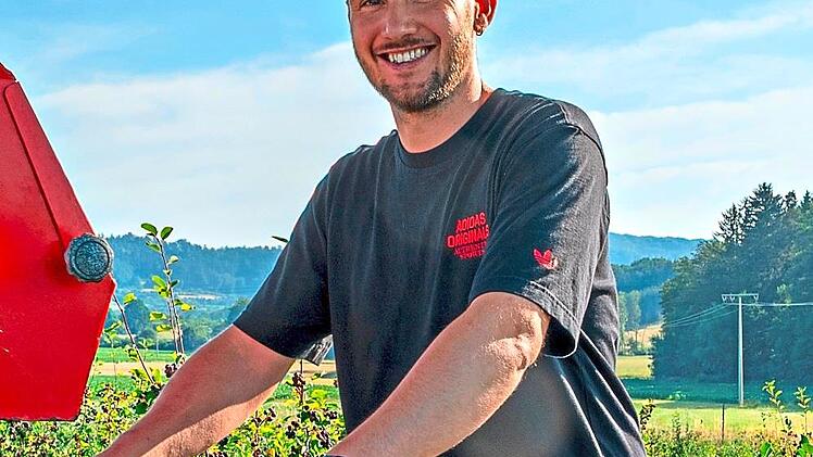 Lukas Schmitt steht auf der der Erntemaschine.
