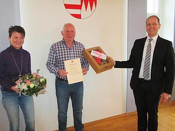 Bürgermeister Johannes Krumm (r.) verabschiedete den Leiter des Gemeindebauhofs, Leo Roth, mit der Dankesurkunde und einem Präsent, das auch Gattin Martina Roth (l.) erhielt.