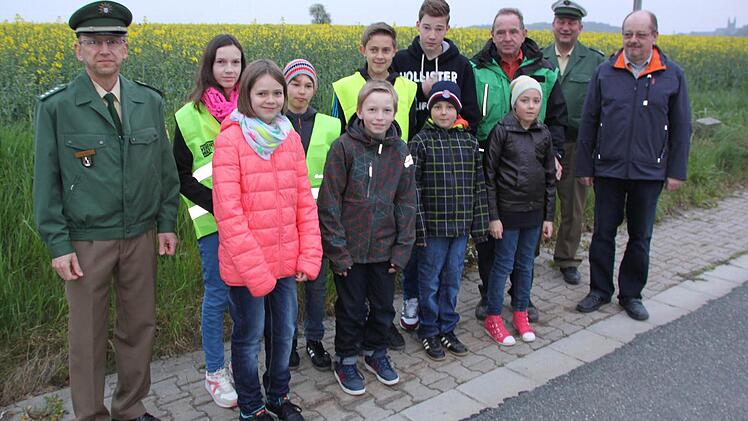 An der Bushaltestelle: Die neuen Schulbushelfer mit den Vertretern der Polizei und der Verkehrswacht