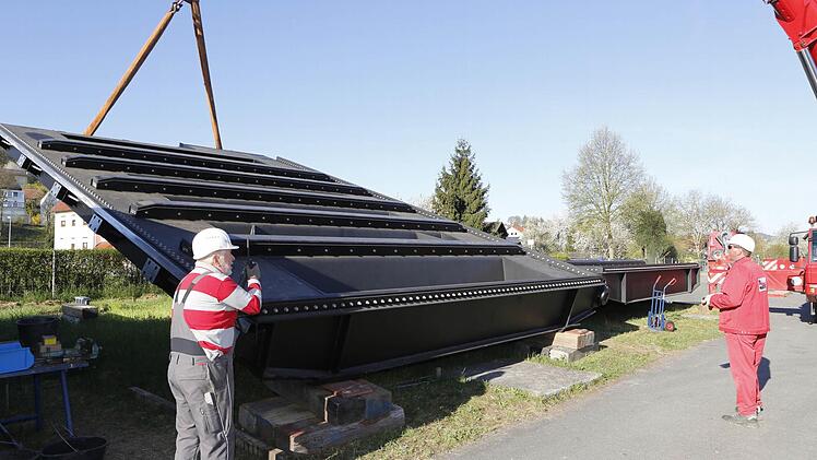 Montageleiter Hubert Stutzke (links) vor dem noch liegenden Tor, das über das Wasser nach Viereth geschippert wurde. Foto: Matthias Hoch
