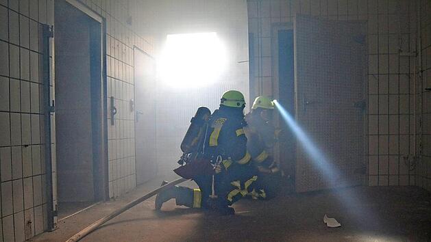 Atemschutzger&auml;tetr&auml;ger durchsuchen die R&auml;ume der alten Metzgerei. K&uuml;nstlicher Nebel erschwerte ihre Arbeit.  Fotos: Johannes Schlereth