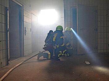 Atemschutzgeräteträger durchsuchen die Räume der alten Metzgerei. Künstlicher Nebel erschwerte ihre Arbeit.  Fotos: Johannes Schlereth
