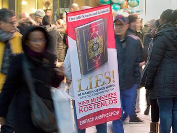 Mit einem Plakat auf dem R&uuml;cken versucht ein Teilnehmer der Koran-Verteilaktion &laquo;Lies!&raquo; am 31.01.2015 auf der Zeil in Frankfurt am Main (Hessen) die Aufmerksamkeit auf sich zu ziehen. Archivfoto: Boris Roessler/dpa