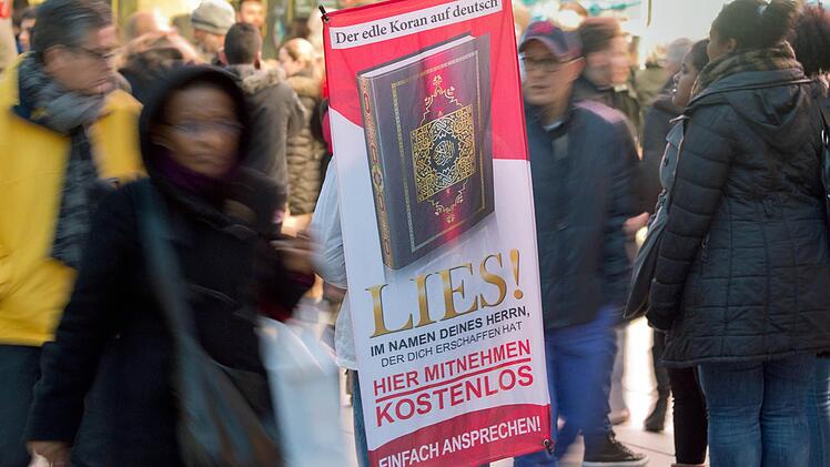 Mit einem Plakat auf dem R&uuml;cken versucht ein Teilnehmer der Koran-Verteilaktion &laquo;Lies!&raquo; am 31.01.2015 auf der Zeil in Frankfurt am Main (Hessen) die Aufmerksamkeit auf sich zu ziehen. Archivfoto: Boris Roessler/dpa