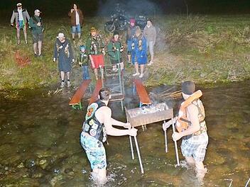 Der Grill wird vom Ufer in das kniehohe Wasser der Tettau getragen und verankert. Foto: Karl-Heinz Hofmann