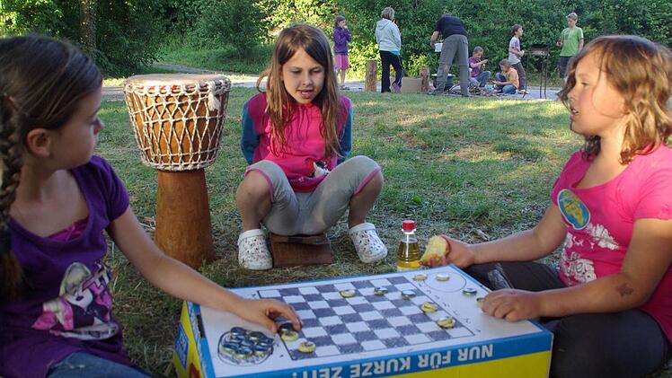 Damespiel selbst gemacht: Meike, Svenja und Annika vergnügen sich am Gemüsekarton, auf dem  mit Kronkorken gespielt wird. Fotos: Elisabeth Assmann
