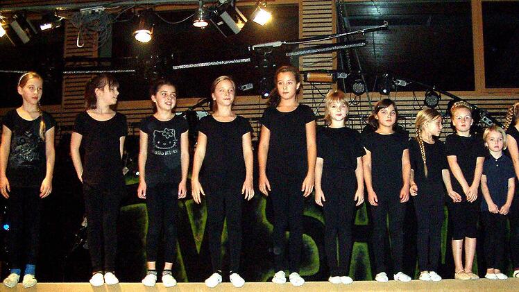 Eine starke Gruppe sind die Nachwuchsgeräteturnerinnen - hier  wie schwarze Vögelchen  in einer Reihe auf dem Schwebebalken.