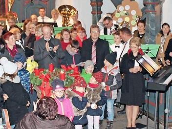 Am Ende des gelungenen Adventskonzerts versammelten sich alle Akteure im Altarraum und sangen mit dem Publikum das Abschlusslied.  Foto: jf