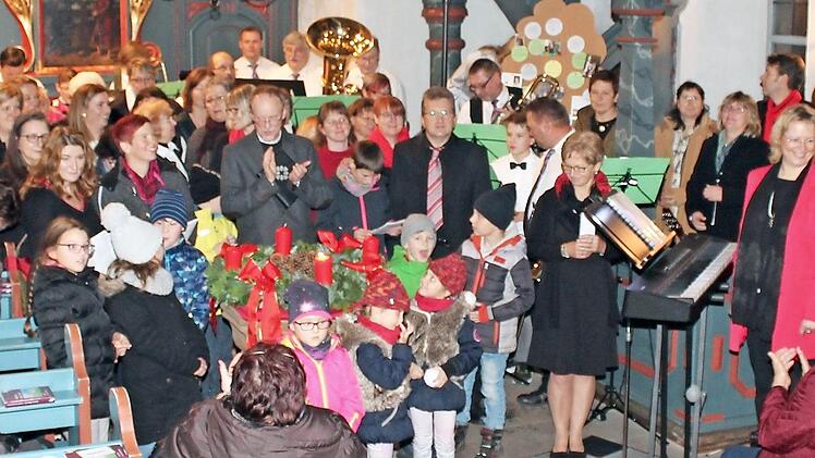 Am Ende des gelungenen Adventskonzerts versammelten sich alle Akteure im Altarraum und sangen mit dem Publikum das Abschlusslied.  Foto: jf