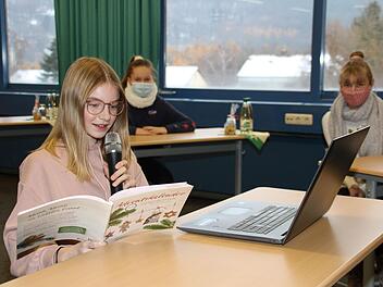 Clara Köstner demonstriert, wie der Geschichten-Adventskalender entstanden ist. Mit im Bild sind im Hintergrund Aileen Schuster und Amelie Schneider. Dagmar Besand
