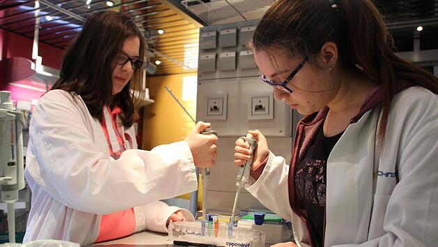 Biologie muss nicht langweilig sein: Isabelle Mundo (links) und Zoe Schwalb (rechts) arbeiten mit Pipetten im Biotechnikum-Truck. Foto: Franziska Rieger