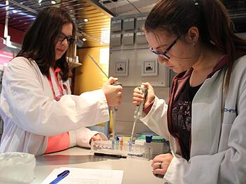 Biologie muss nicht langweilig sein: Isabelle Mundo (links) und Zoe Schwalb (rechts) arbeiten mit Pipetten im Biotechnikum-Truck. Foto: Franziska Rieger