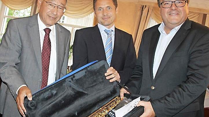 Die Geschäftsführer Oliver und Nikolaus Wiegand bedanken sich bei Matthias Fröba (links) mit einem Saxophon. Foto: Veronika Schadeck
