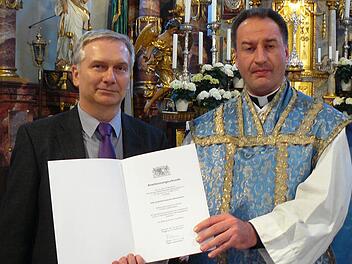 Der Vorsitzende des Förderverein "Freunde der Wallfahrtsbasilika Marienweiher", Monsignore Professor Rüdiger Feulner (rechts), nahm am Altar die Stiftungsurkunde von Leitendem Regierungsdirektor Armin Helbig entgegen. Foto: Klaus-Peter Wulf