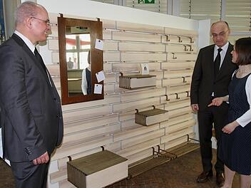 Meisterin Rebekka Weise stellt hier ihr Meisterstück, eine besondere Garderobe, Landrat Wilhelm Schneider (Zweiter von rechts) und Schulleiter Oliver Dünisch (links) vor.Günther Geiling