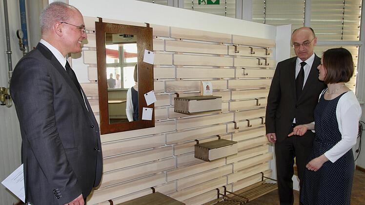 Meisterin Rebekka Weise stellt hier ihr Meisterstück, eine besondere Garderobe, Landrat Wilhelm Schneider (Zweiter von rechts) und Schulleiter Oliver Dünisch (links) vor.Günther Geiling