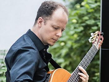 Gitarrist und Dichter: Christian Rosenau bei seiner musikalischen Lesung in der Stadtbücherei Coburg.Foto: Jochen Berger