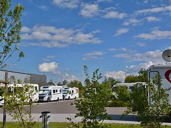 Die ersten Wohnmobilisten sind bereits am Wochenende in Bad Königshofen angereist. Sie genießen die Sonne in familiärer Runde. Foto: Hanns Friedrich