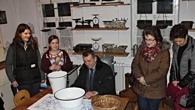 Stellvertretender Landrat Oskar Ebert hat in einer "alten Küche" im Heimatmuseum Ebern Platz genommen, um sich von den beiden Führerinnen, Sandra Rögner und Celina Kaiser (von links) Gepflogenheiten früherer Zeit erklären zu lassen. Aufmerksam lauschte auch Sibylle Kneuer(rechts) den Ausführungen der beiden jungen Damen.  Foto: Helmut Will